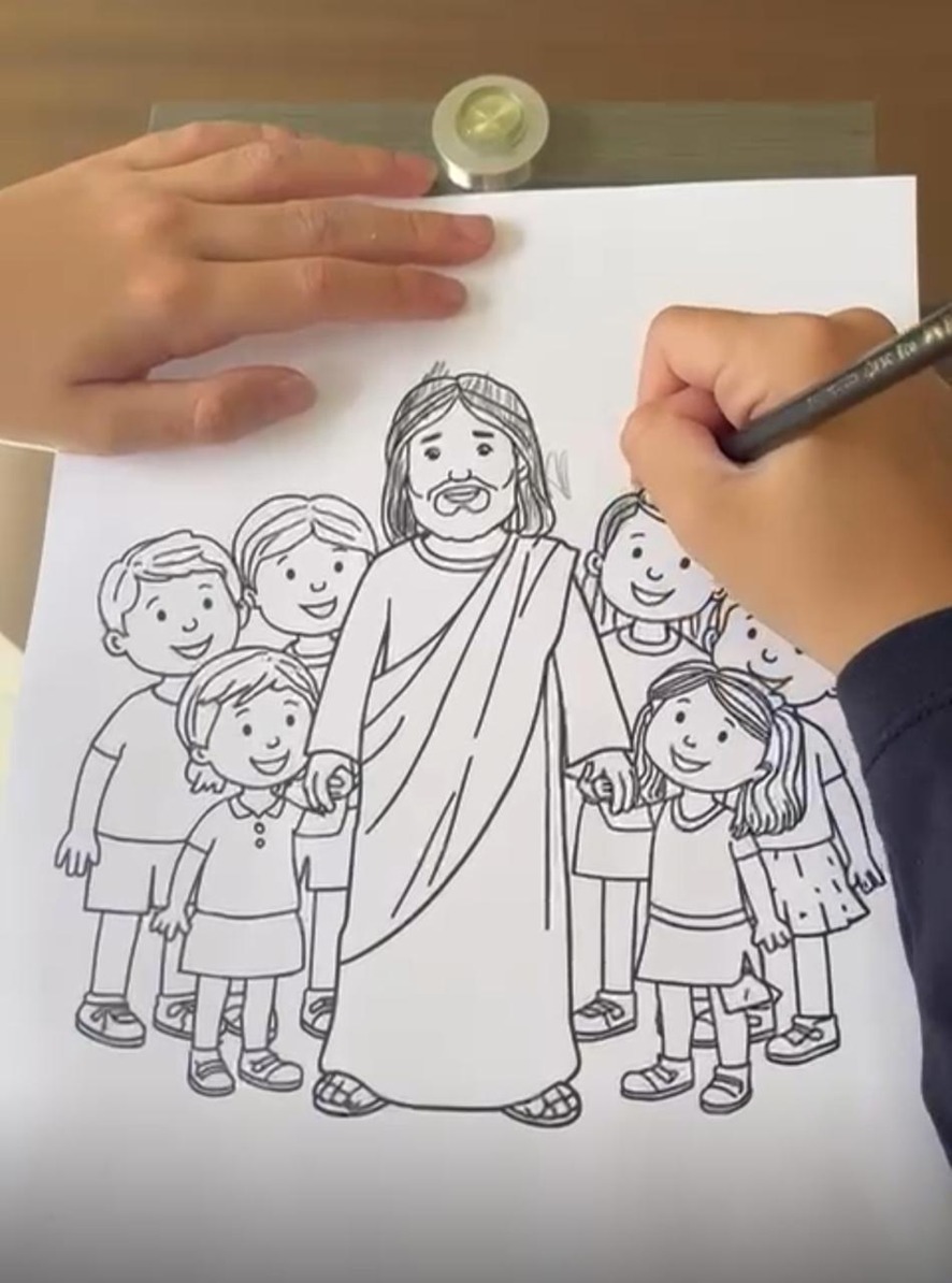 Criança colorindo Jesus rodeado de crianças — atividade do kit, foco em valores cristãos